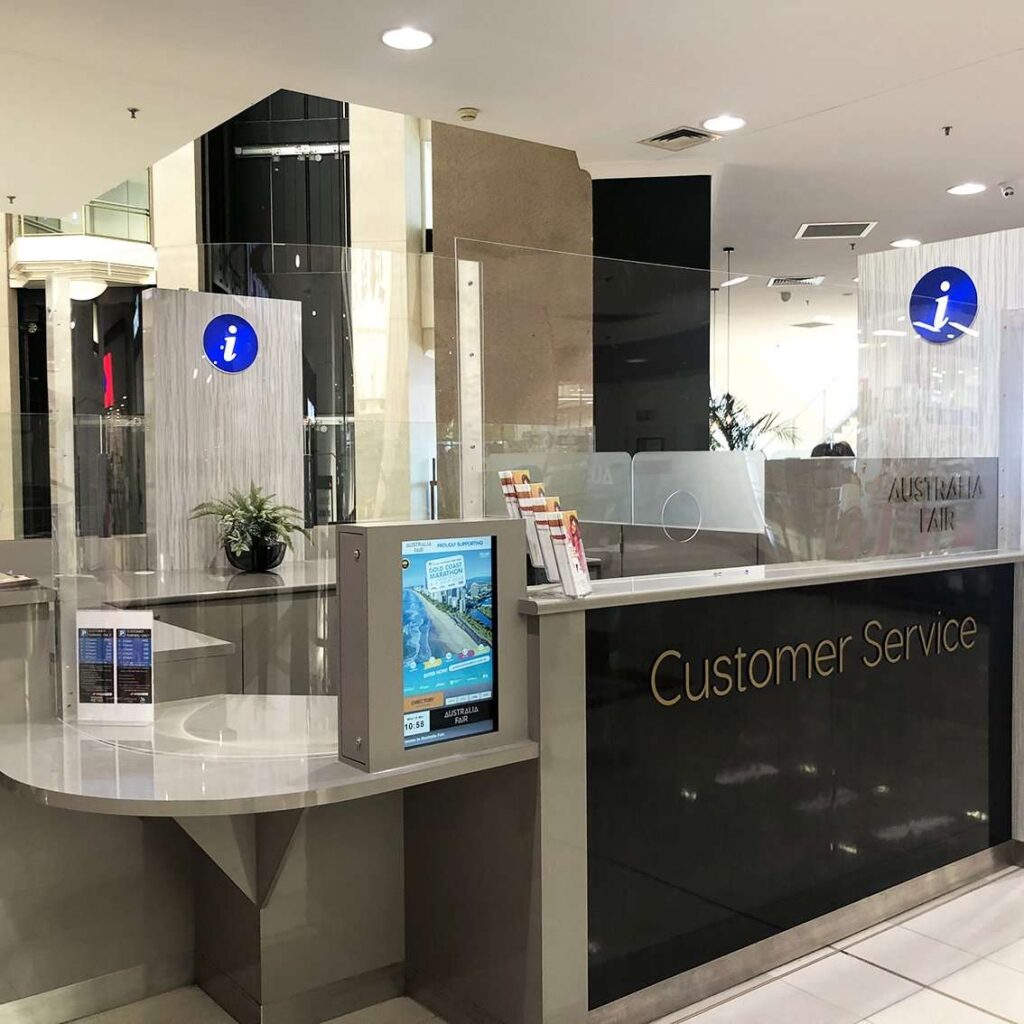 custom clear acrylic sneeze guard on shopping centre customer service kiosk